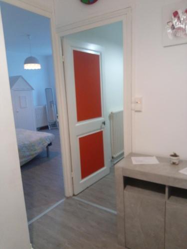 Zimmer mit einer roten Tür und einem Zimmer mit einem Bett in der Unterkunft vieux-Cognac, chambre avec sa salle de bain privative in Cognac