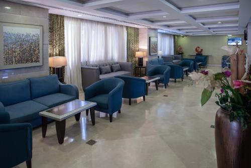 a waiting room with blue couches and chairs at Al Kiswah Towers Hotel in Makkah