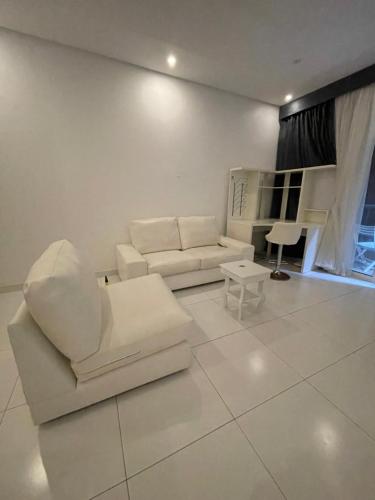 ein Wohnzimmer mit weißen Möbeln und einem Klavier in der Unterkunft درة العروس فيلا البيلسان الشاطي الازرق in Durrat Al-Arus