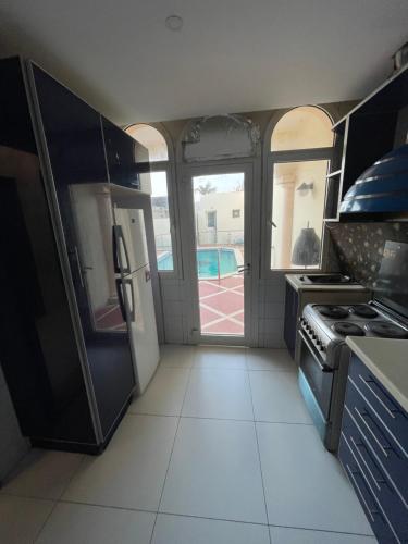 a kitchen with a refrigerator and a stove top oven at درة العروس فيلا البيلسان الشاطي الازرق in Durat  Alarous