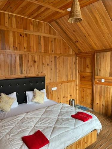 a bedroom with a bed with red pillows on it at Odin Hostel Shoja in Shoja