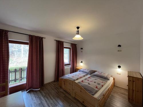 a bedroom with a bed and a window at Pension & Apartments Waldkrieber in Presseggersee