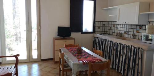 a kitchen with a table with chairs and a sink at Terrazza sul mare Scopello in Scopello