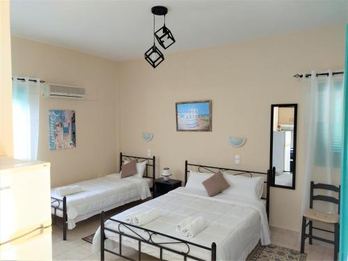 ティロスにあるMouragio Apartmentsのベッドルーム1室(ベッド2台、鏡付)