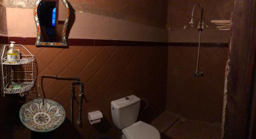 uma casa de banho com um WC, um chuveiro e um espelho. em La Fibule D'or em Aït-Ben-Haddou