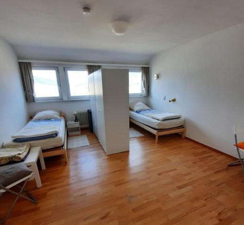 a room with two beds and a wooden floor at Business Apartment Aida in Baiersbronn