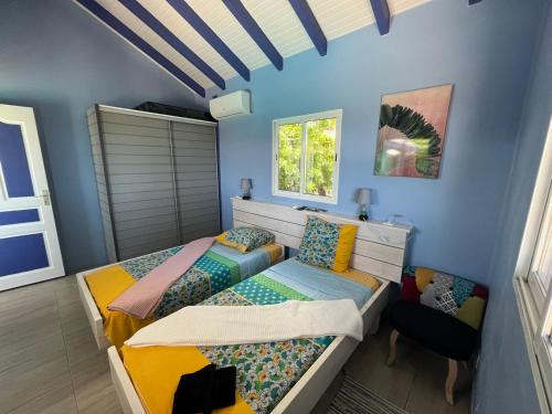 1 dormitorio con 2 camas y 1 silla en AWMONY'KAZ, Gite à Trois-Rivières GUADELOUPE en Trois-Rivières