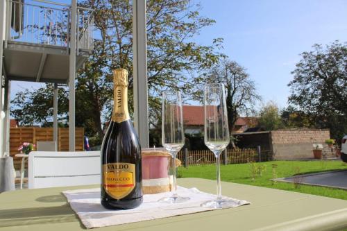 a bottle of champagne and two wine glasses on a table at Willy´s Ferienzimmer im Tabakdorf Hatzenbühl 