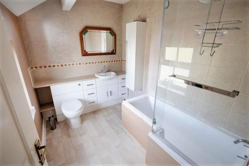 y baño con aseo, bañera y lavamanos. en Quiet 2 Bedroomed Cottage, near the Lakes en Carnforth