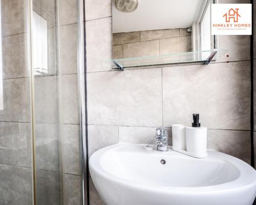 y baño con lavabo y espejo. en Large & Spacious 3 Bedroom House with Parking & Wifi By Hinkley Homes Short Lets & Serviced Accommodation en Liverpool