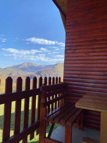 a wooden bench sitting on the porch of a cabin at Ethno village & resort Ćorić in Mojkovac
