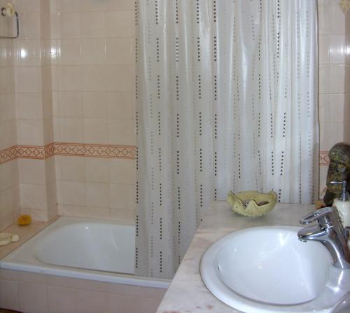 a bathroom with a tub and a sink and a bath tub at Sesimbra4you in Sesimbra