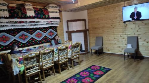 a room with a group of chairs and a flat screen tv at Casa Utan in Văleni