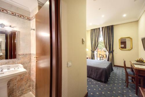 a hotel room with a large bed and a large mirror at Hotel Artorius in Rome