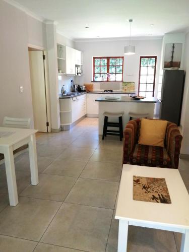 a kitchen and living room with a couch and a table at Gästehaus HelderbergView in Somerset West