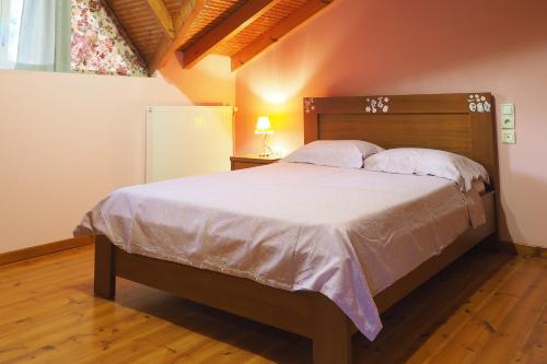 1 dormitorio con 1 cama grande y cabecero de madera en ΚΑΛΟΣΚΟΠΗ Luxury House, en Kaloskopí