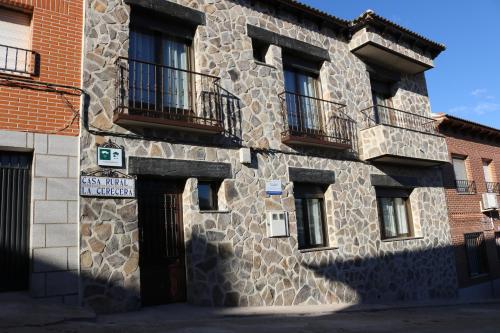 a stone building with balconies on the side of it at Casa Rural "La Cerecera" in Los Navalucillos