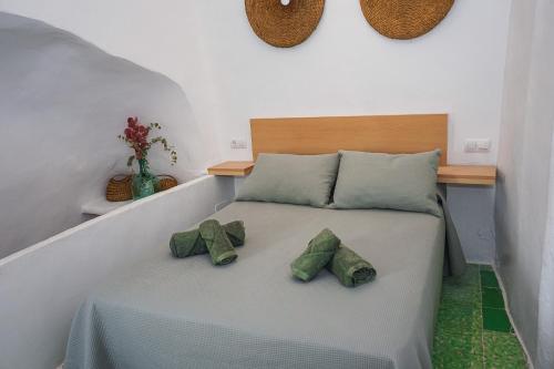 a bed with two green pillows on it at Casa Frasquita in Cehegín