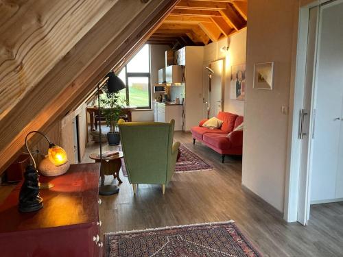 a living room with a red couch and a table at Gastenverblijf Chambre dAmis in Heers