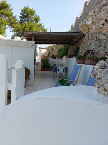 a patio with chairs and a table in a yard at Casadelpino Residence La Piana in Ponza