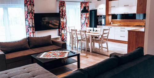 uma sala de estar com um sofá, uma mesa e uma cozinha em LB Domek w centrum Willowa 3 em Szczyrk