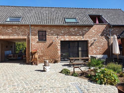 a brick building with a patio and a picnic table at B&B Dekorn in Pepingen