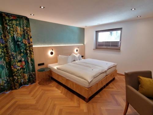 ein Schlafzimmer mit einem großen Bett und einem Fenster in der Unterkunft Haus Marion Haueis in Sankt Anton am Arlberg