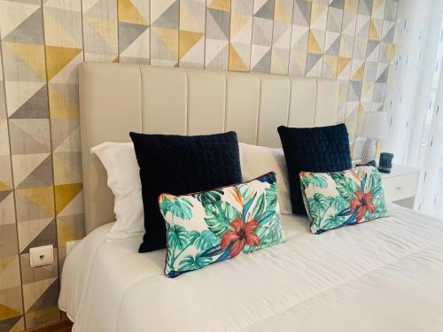 a white bed with two pillows on top of it at CASA MR in Nazaré