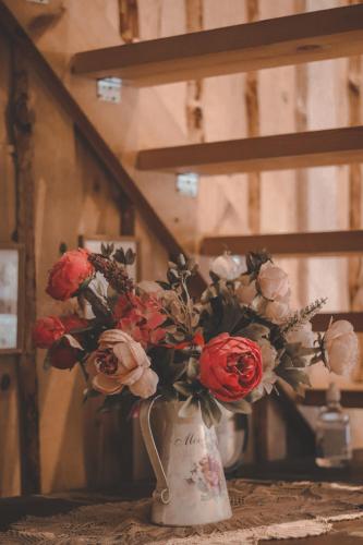 a white vase filled with red and white flowers at Samblatalu Homestay in Laulasmaa