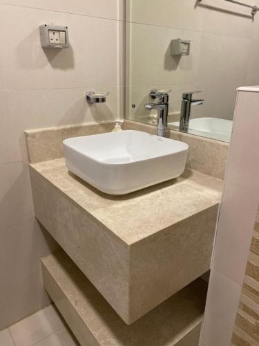 a white sink in a bathroom with a mirror at Lovely Beach Apartment in Salalah