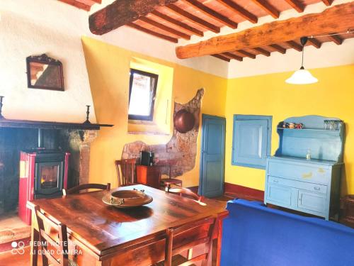 een kamer met een houten tafel en een blauwe bank bij La casa di Iara in Pitigliano