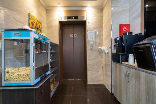 una habitación con puerta y una habitación con máquina de comida en Galleria Hotel, en Suwon