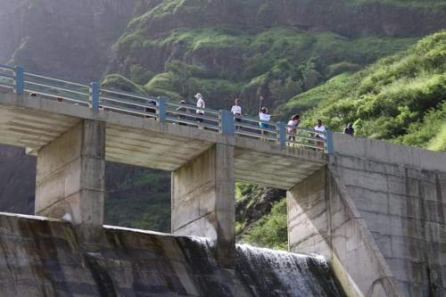 Un gruppo di persone che camminano su un ponte sopra una cascata di Pam de Terra a Calheta