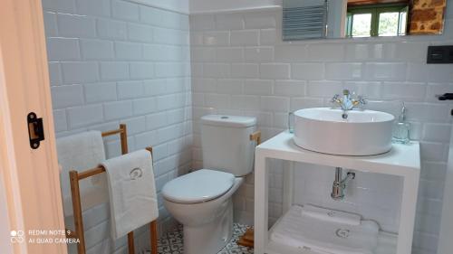 a white bathroom with a toilet and a sink at Casa el rey 12 - Apartamentos Buenos Aires y Figueras 