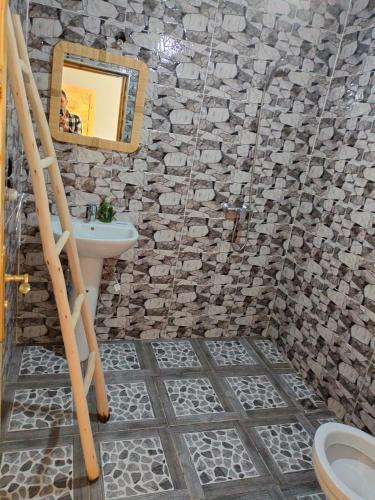 Baño de piedra con lavabo y espejo en Riad otos views, en Imlil