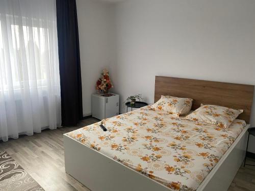 a bedroom with a bed with a floral comforter at Casa Zeus in Seini