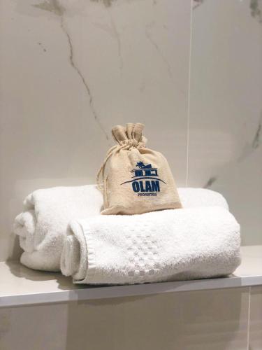 une pile de serviettes et d'un sac sur une étagère dans l'établissement Général Ferrié 3 pcs AR Croisette Martinez by Olam Properties, à Cannes