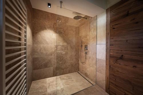 a bathroom with a shower with a glass door at Cozy Loft in the Alps of Zillertal in Schwendau