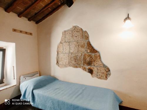 een slaapkamer met een groot artefact aan de muur bij La casa di Iara in Pitigliano