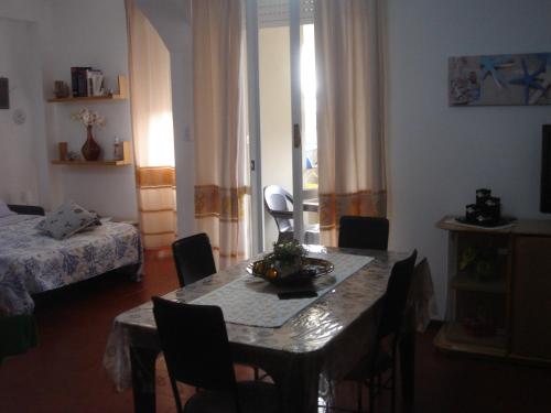 Habitación con mesa con sillas y cama en Casa vacanze Lunatya, en Alghero