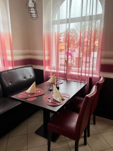a dining room table with two chairs and a window at Hotel-Gasthof "Alter Ritter" in Rothenburg ob der Tauber