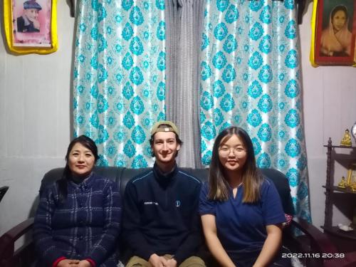 a man and two women sitting on a couch at DukeRaj Homestay in Darjeeling