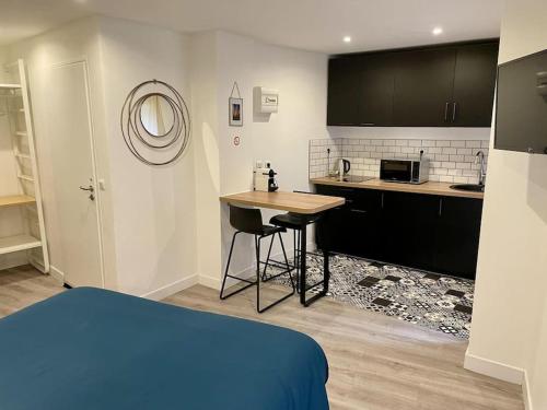 Pokój z łóżkiem i kuchnią ze stołem w obiekcie Le Moulin 3 - Appartement Tout Confort Centre Ville - Beziers - Wifi - Tv connecté w Béziers