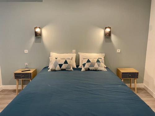1 Schlafzimmer mit einem blauen Bett und 2 Nachttischen in der Unterkunft Le Moulin 3 - Appartement Tout Confort Centre Ville - Beziers - Wifi - Tv connecté in Béziers