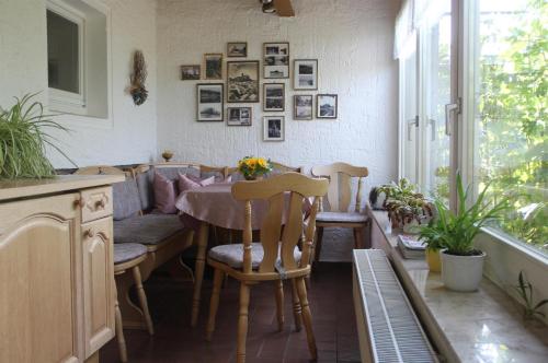 jadalnia ze stołem i krzesłami oraz oknem w obiekcie Pension Elbblick Sabine Zuschke w mieście Miśnia