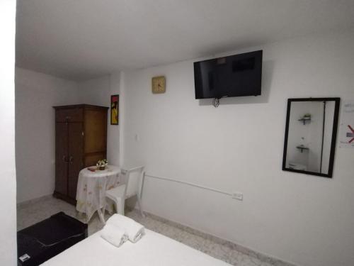 a room with a table and a tv on a wall at HABITACION CERCA DE LA UNIVERSIDAD DEL Sinu in Cartagena de Indias