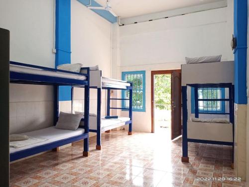 a room with three bunk beds and a hallway at Silver Dolphin Guesthouse & Restaurant in Kratie