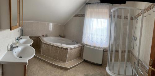 a bathroom with a tub and a sink and a shower at Rovinka Apartmán Petátos in Rovinka