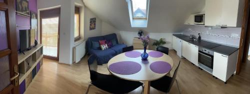 a living room with a table and a kitchen at Rovinka Apartmán Petátos in Rovinka