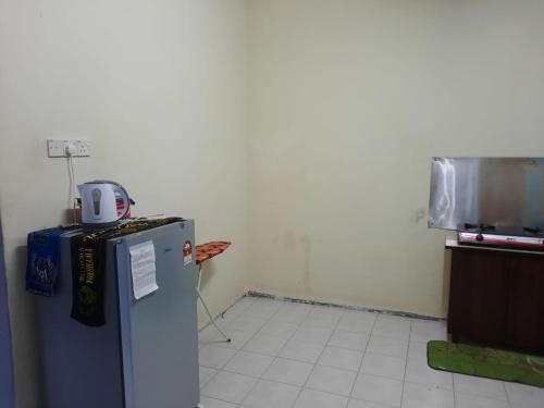 a small kitchen with a refrigerator in a room at Jerai Geopark Cottage 3 bedrooms -Pulau Bunting in Yan